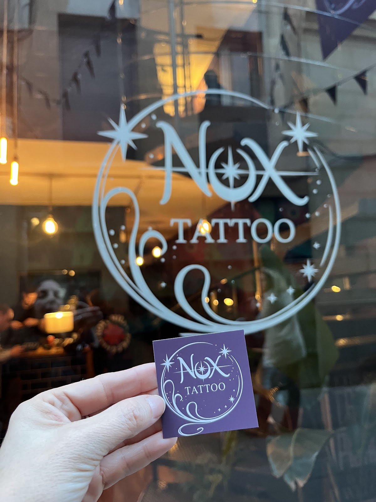 El logo de Nox Tattoo grabado en el cristal del escaparate